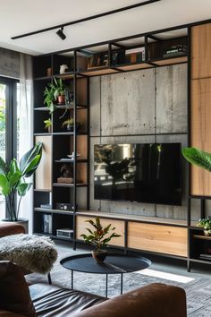 a living room filled with furniture and a flat screen tv mounted on a wall next to a window