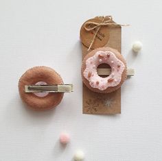 two donuts are tied up on a piece of brown paper and some tiny white balls