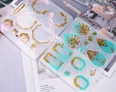 several pieces of jewelry sitting on top of a white table next to other items and papers