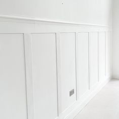 an empty room with white paneling on the walls