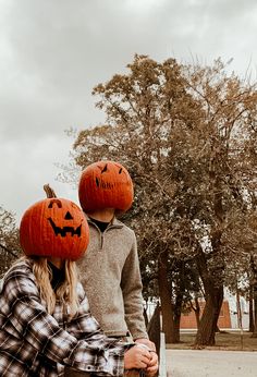 two people wearing pumpkin hats sitting on a bench