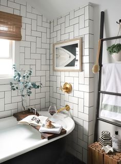 a bath room with a tub and a mirror on the wall next to a window