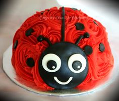 a red and black cake with a lady bug on it