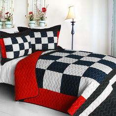 a black and white checkered quilted comforter with red accents on the bed