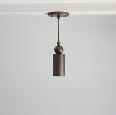 a light fixture hanging from the ceiling in a room with white walls and flooring