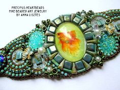 a brooch with an image of a goldfish in it's center surrounded by beads