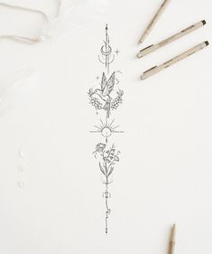 some pencils are laying on top of a piece of paper with an intricate design