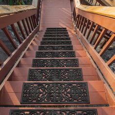 the stairs lead up to the top of this wooden building with wrought iron railings