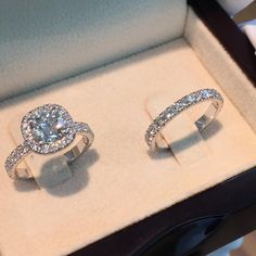 two engagement rings sitting in a box on display