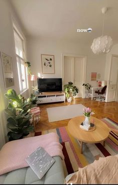 a living room filled with furniture and a flat screen tv sitting on top of a wooden table