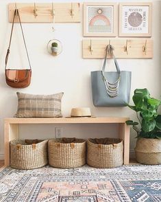 a bench with baskets on it in front of a wall filled with pictures and plants