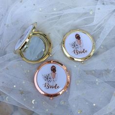 two compact mirrors with the bride and groom's names on them sitting on a white fabric