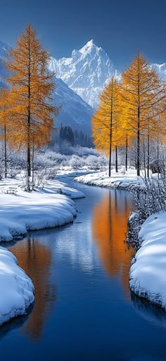 a river surrounded by snow covered trees with mountains in the background and orange leaves on them