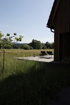 two benches sitting in the grass near a building