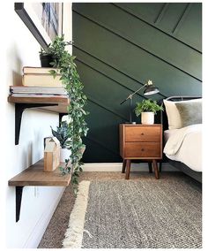 a bed room with a neatly made bed next to a night stand and two shelves