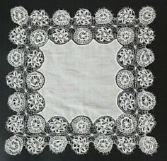 a white doily with black trim on a black background