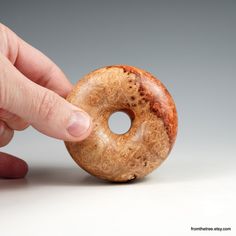 a person is holding a donut in their left hand and touching the doughnut