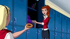 a woman handing a donut to another woman in front of lockers at school