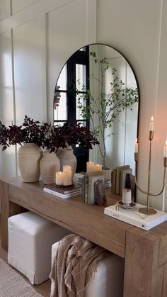 a wooden table topped with a mirror and candles