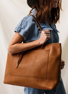 The bigger the tote, the better. Our oversized tote makes sure you can fit everything you could possibly need for work or travel. Laptops, water bottles, books - you name it, this leather tote can take it on. The Oversized is made with our full-grain leather that is soft, but sturdy. The solid bottom helps this tote keep its shape day in and day out. An accessory strap with solid brass hardware is included. Olive Tan, Vintage Tote Bag, Leather Tote Bags, Oversized Tote, Perfect Tote Bag, Aging Well, Tote Bag Leather, Accessories Storage, Large Tote