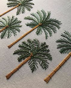 embroidered pine trees on white linen with twine and burlocked stems in the center