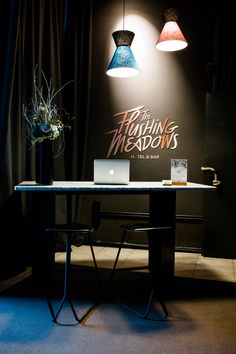 a laptop computer sitting on top of a wooden table next to a lamp and chair