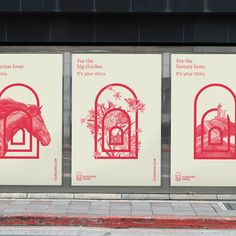 three red and white posters on the side of a building next to a sidewalk with a horse