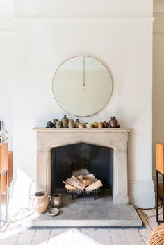 a living room with a fire place and mirror on the wall above it's mantle