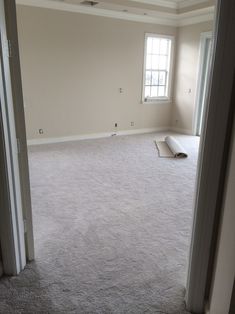 an empty living room with carpeted floors and no one in the house or apartment