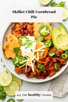 a bowl filled with chili, cheese and avocado on top of a table