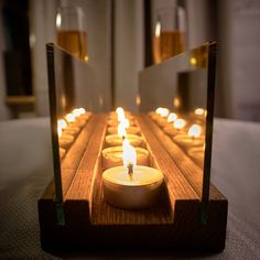 a row of candles sitting on top of a wooden table