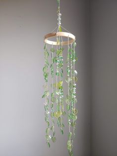 a chandelier with green glass beads hanging from it's side in a room