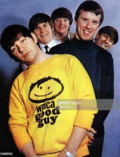 a group of men standing next to each other in front of a blue wall with the words who's good guy written on it