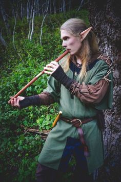 a woman dressed in elf costume playing the flute