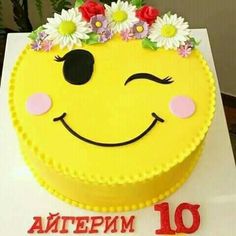 a yellow cake decorated with flowers and smiling face