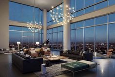 a living room filled with lots of furniture and large windows overlooking the city at night