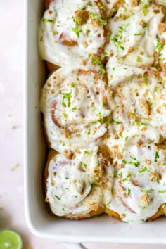 a casserole dish filled with meat and cheese covered in sour cream, garnished with chopped green onions