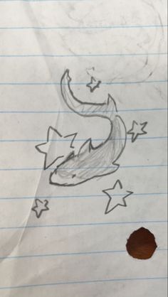 a piece of paper with a drawing of a fish on it's side and stars in the background