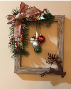 a wooden frame with ornaments hanging from it's sides and a deer ornament in the middle