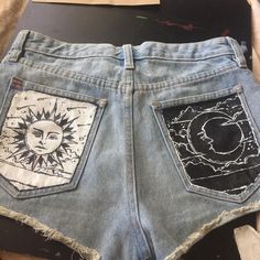 a pair of jean shorts with sun and moon patches