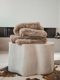 two towels stacked on top of each other in a room with cow hide rugs