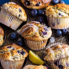 blueberry muffins on a tray with lemon wedges and fresh blueberries