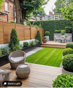 an outdoor garden with wooden decking, grass and potted plants