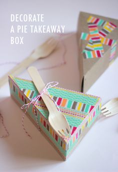 two cardboard boxes with forks and spoons in them on a white table top, the box is decorated as a pie takeaway box