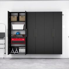 an organized garage with black cabinets and white walls, including storage bins for items