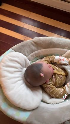 a baby is laying in a bed on the floor