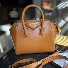 Only Used A Couple Of Times. It’s In Perfect Condition! It’s Just Not A Bag I Reach For When Compared To My Others. Comes With Original Shoulder Strap, Dust Bag, Receipt/Authenticity Tag. Accepting Reasonable Offers. This Bag Is $1950 Plus Tax In Stores, And This Color Is Extremely Hard To Find. Purchased At Givenchy In Miami. Givenchy Box Calf Leather Satchel Bag With Silvertone Hardware. Rolled Tote Handles; 2.3" Drop. Removable Flat Shoulder Strap; 21" Drop. Extended Zip Top Closure. Envelope Luxury Handheld Brown Satchel, Designer Cognac Bag With Top Carry Handle, Classic Brown Satchel With Dust Bag, Designer Cognac Shoulder Bag For Business, High-end Brown Satchel For Formal Occasions, Light Brown Top Handle Bags For Formal Occasions, Luxury Light Brown Satchel For Travel, Luxury Light Brown Travel Satchel, Cognac Top Handle Satchel With Dust Bag