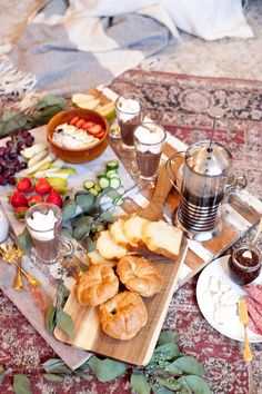 an assortment of food and drinks on a wooden tray with red carpet in the background