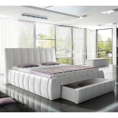 a white bed sitting inside of a bedroom on top of a hard wood floor