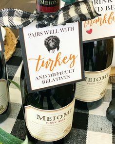 three bottles of wine sitting on top of a black and white checkered table cloth